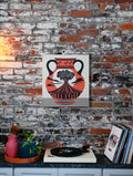 This is a canvas print design of an ancient clay vase depicting a volcanic eruption. The vase is accented with unique patterns like lightning bolts and meanders. The art is displayed in a modern eclectic home. 