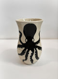 Ceramic vase with black octopus design on a white background