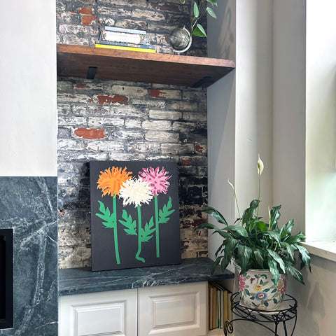 Contemporary wall art with orange white and pink chrysanthemums displayed in a modern home