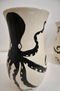 Ceramic vase with black octopus design on a white background