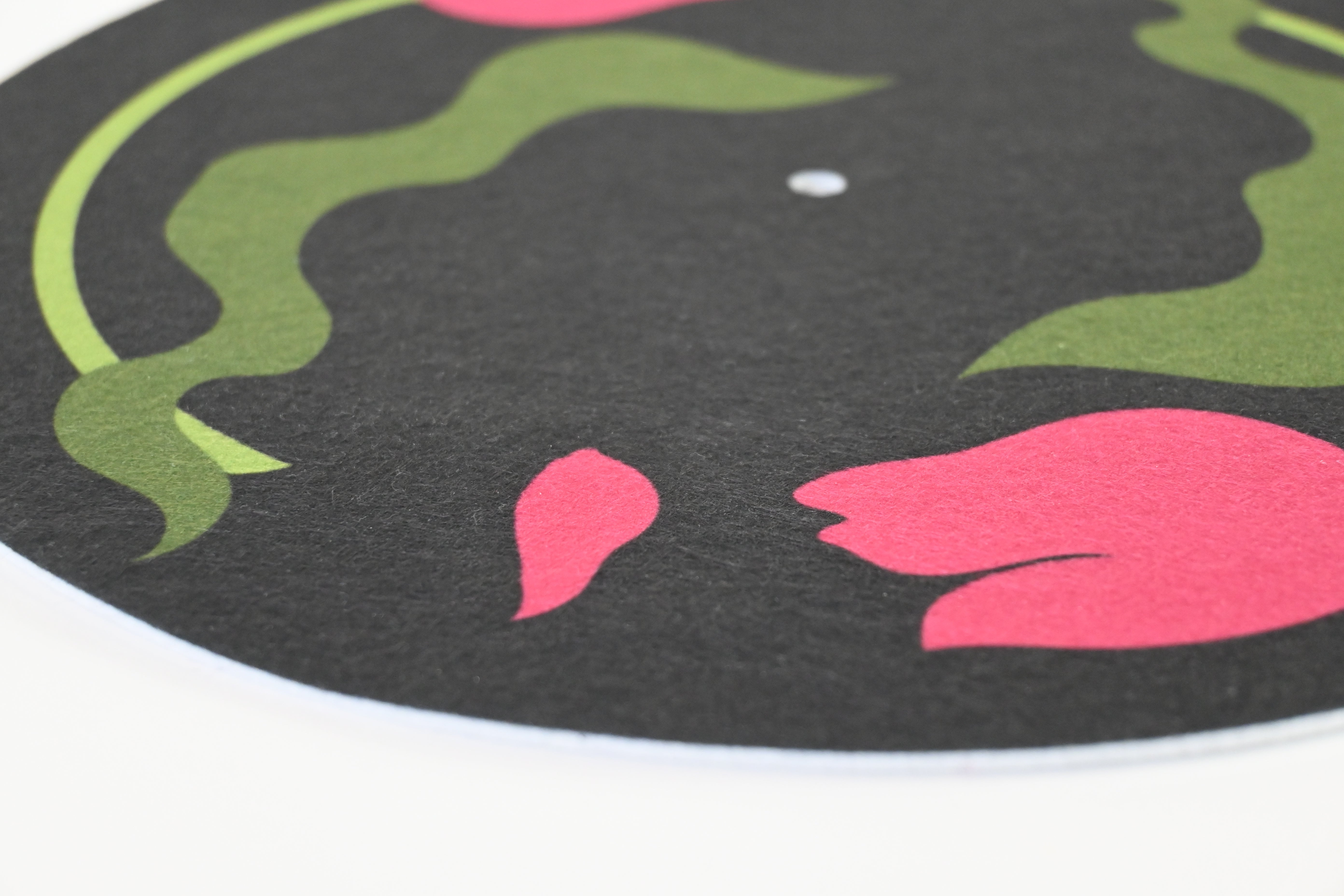 Close-up of a vinyl record slipmat with a floral design on a black background
