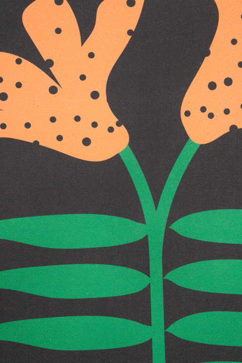 A piece of canvas contemporary art with black background featuring orange lily flowers with green leaves and black dots