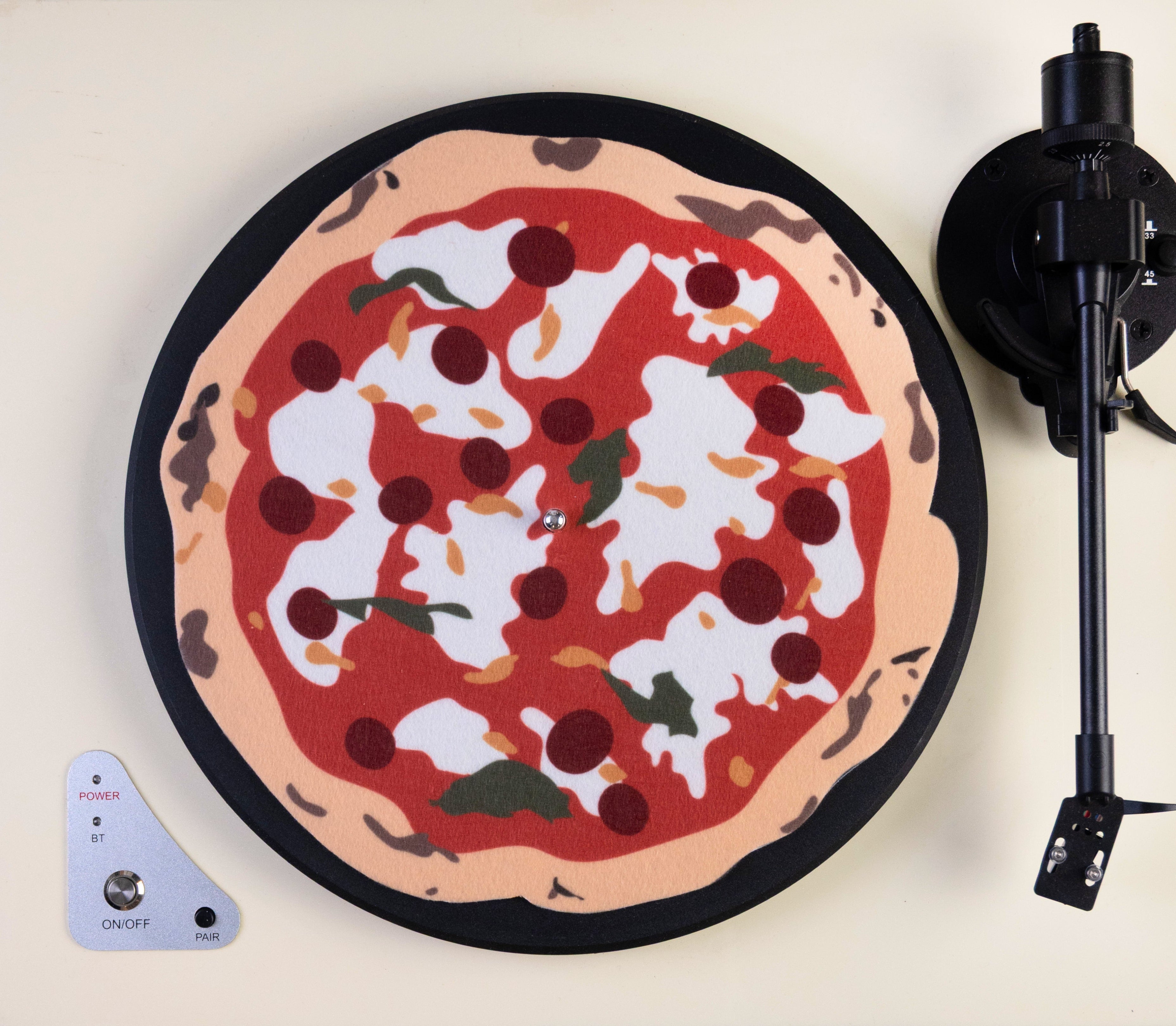 Custom, irregular shaped vinyl record player slipmat with pizza design on a turntable