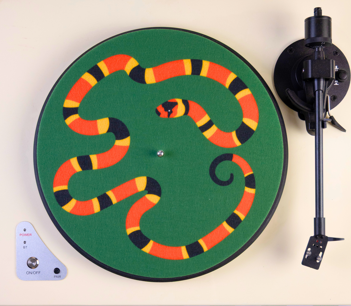 Turntable with a colorful snake slipmat on the platter against a white background