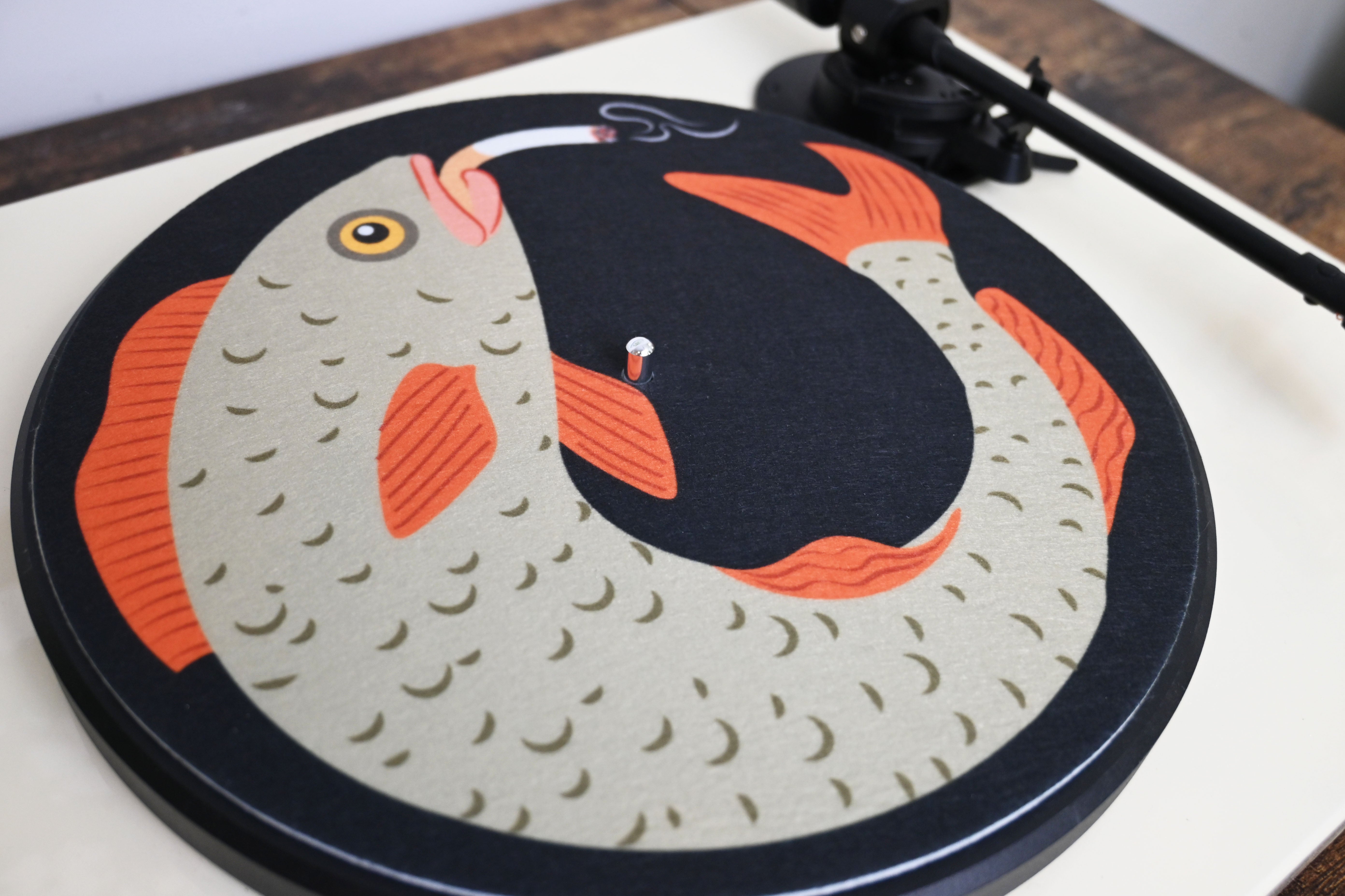 Vinyl record with a smoking fish slipmat on a turntable