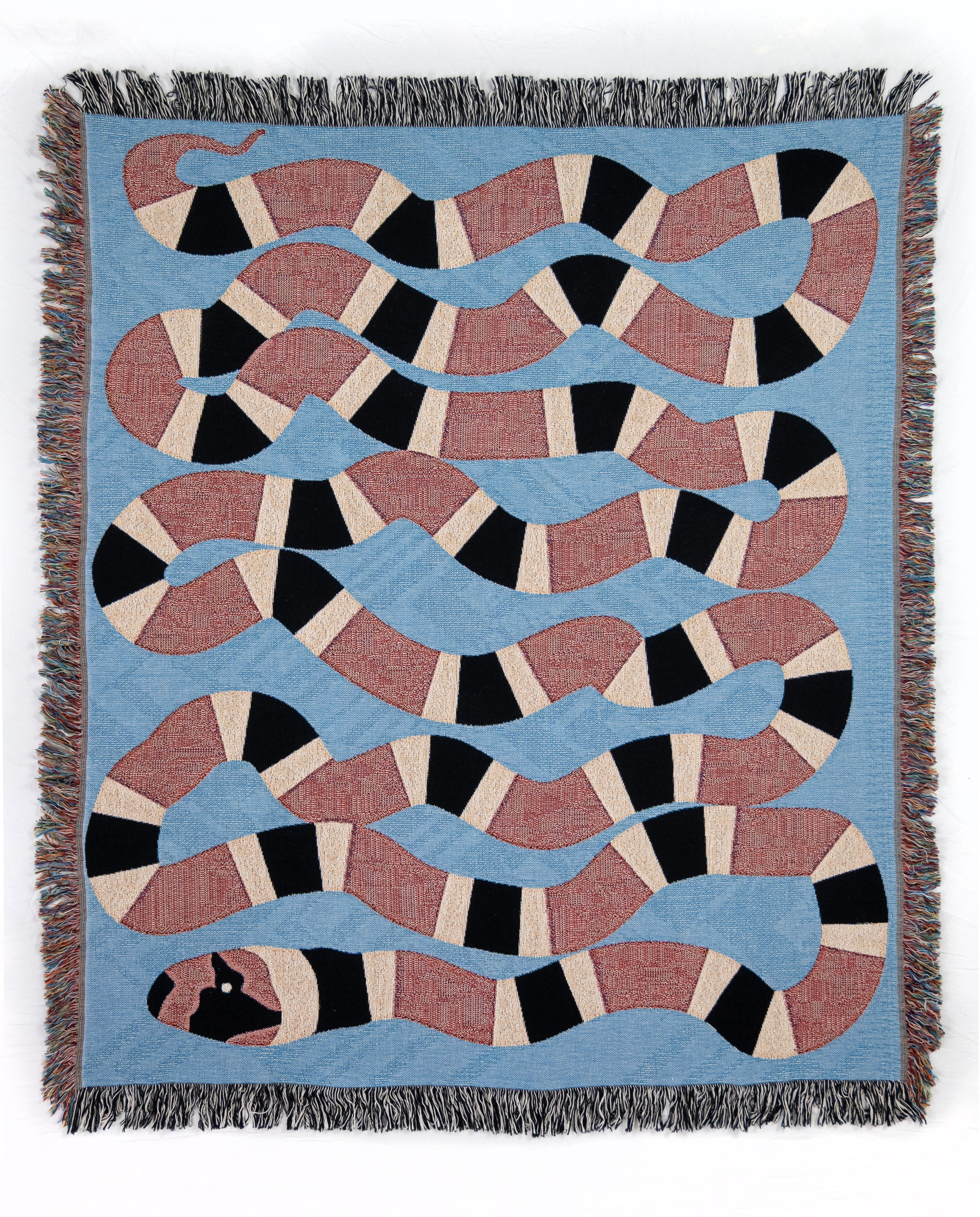 Woven blanket with red and black snake pattern on a blue background