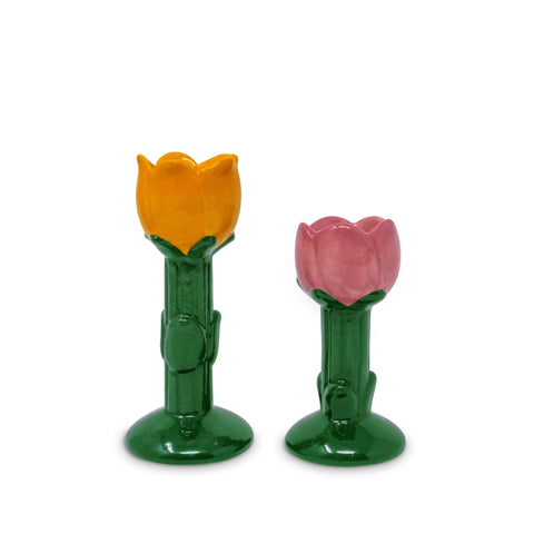 Two tulip-shaped taper candle holders with orange and pink tops on green stems against a white background