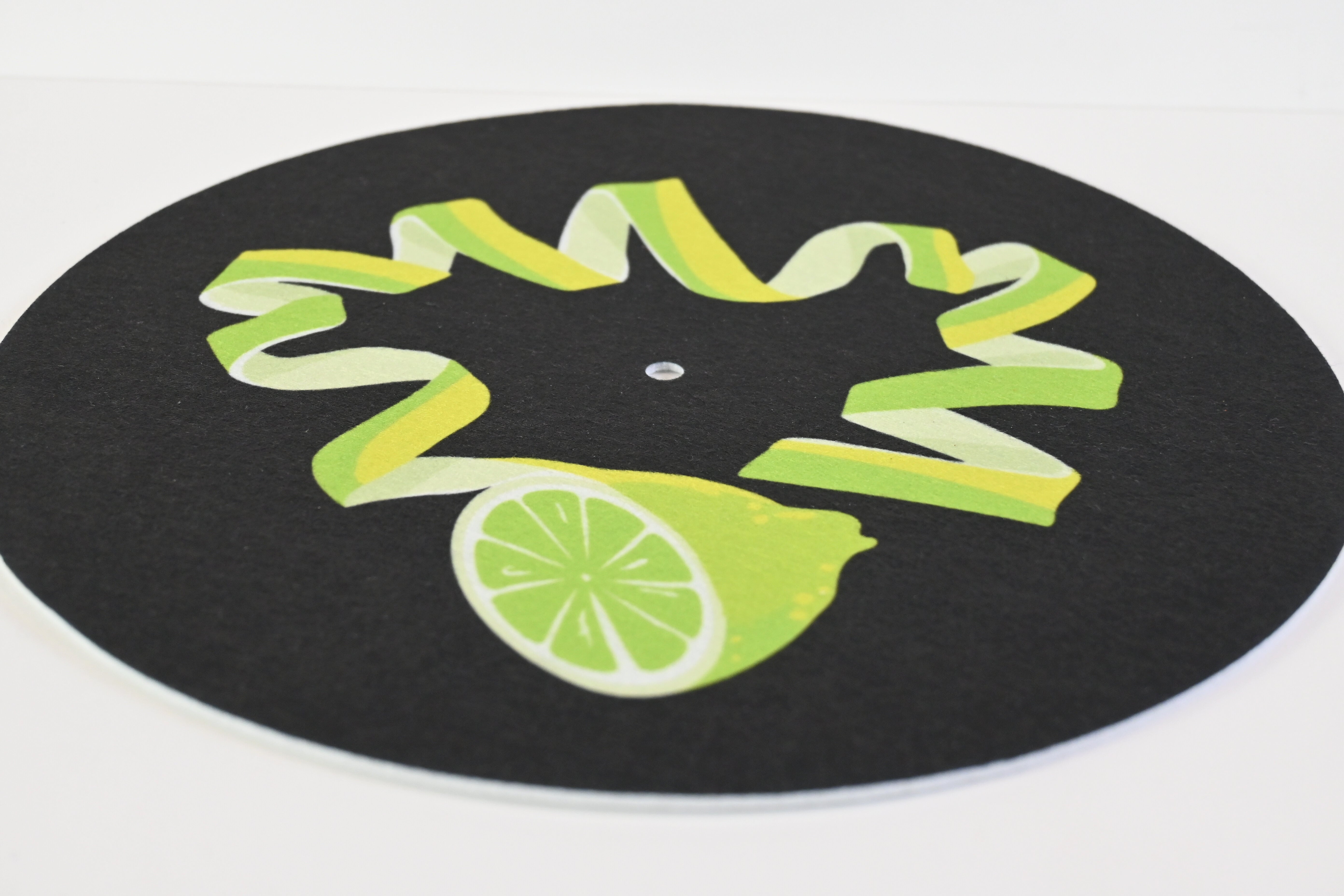 Close up of slipmat with green lime twist design on a black background with green leaves