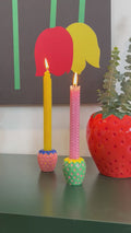 Lit candles in colorful ceramic strawberry candle holders
